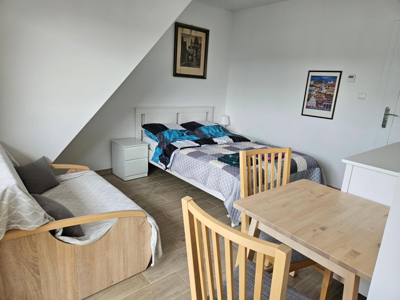 Pokój dwuosobowy z sofą i wyjściem na balkon